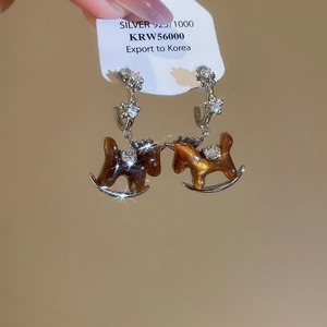 Detail of s925 silver horse earrings with amber resin and sparkling crystals