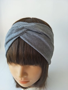 Close-up of grey knitted cross twist headband showing the ribbed fabric and elastic texture