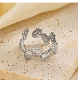 Detailed close-up of silver irregular hammer-textured ring on marble surface