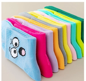 Detail view of colorful stacked cotton socks with cute cartoon embroidery