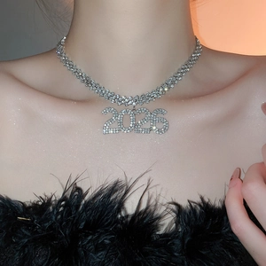 Primo piano di una collana di strass argentati con un ciondolo numero 2026 su una modella