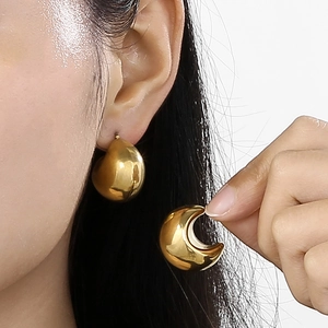 Minimalist gold hollow crescent moon earrings in polished stainless steel on a model