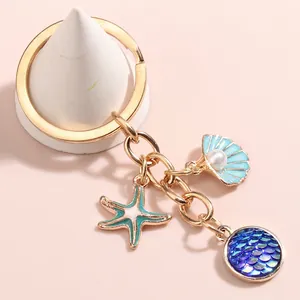 Golden keychain with ocean pendants including shell, starfish and fish scale charms