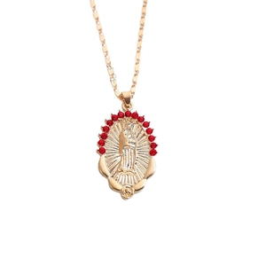 Detailed macro of gold Virgin Mary pendant featuring a halo of radiant red crystals