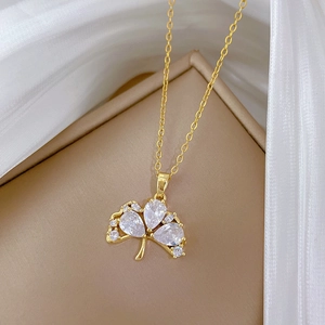 Elegant gold titanium necklace with sparkling ginkgo leaf pendant and clear zircons
