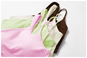 Detail of four seamless sports bras in soft pink, sage green, cream, and dark brown colors