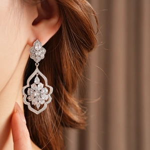 Gros plan de boucles d'oreilles pendantes en argent avec zircons et motifs de fleurs