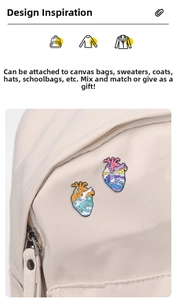 Artistic enamel heart brooch with lighthouse and whale motifs on a canvas bag