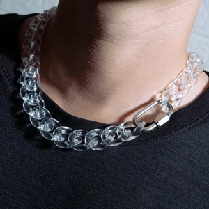 Detail shot of a transparent acrylic thick chain necklace with a silver metal clasp