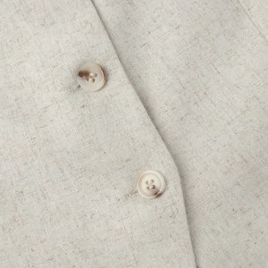Detailed close-up of linen-blend fabric texture and tortoise-shell buttons on the vest
