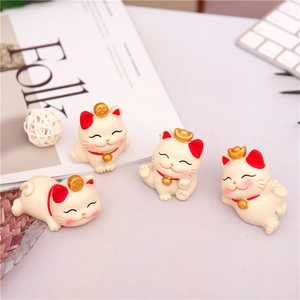 Detailed view of four cream white resin lucky cat figurines in various cute poses