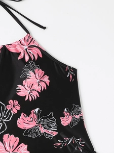 Close-up of tropical floral print on black halter bikini top with fine stitching details