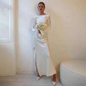 Elegant white satin dress detail featuring long sleeves, side slit, and model holding bouquet