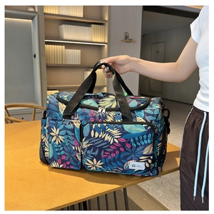 Close-up of travel tote bag with tropical leaf print and exterior zipper pockets