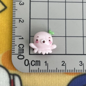Detailed view of mini pink resin octopus charm with ruler showing 1.5cm size scale