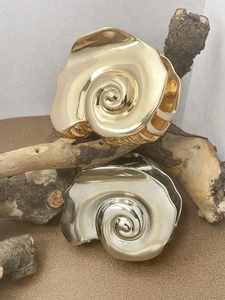 Artistic gold and silver conch-shaped metal hair claws on a natural wooden branch