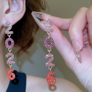 Gros plan sur les boucles d'oreilles 2026 avec strass colorés et glands dorés