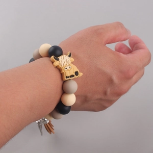 Wristlet view of silicone beaded keychain with highland cow charm and brown tassel