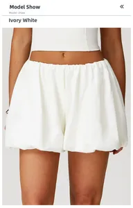 Detail of high-waist ivory white balloon yoga shorts with elastic waist and loose hem