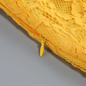 Dettaglio della cerniera invisibile sul tessuto in pizzo giallo vivace con ricami