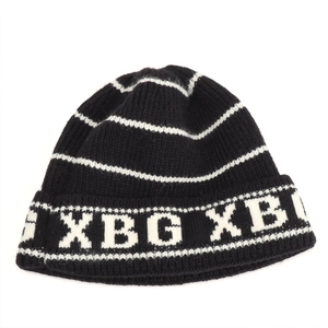 Detailed macro view of black ribbed knit beanie with white stripes and XBG lettering logo