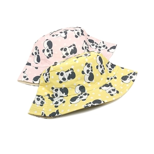 Detail of pink and yellow cotton sun hats with cute panda prints and polka dots for kids
