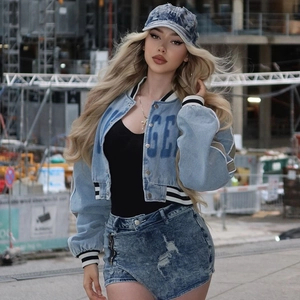 Detail of blue denim crop jacket with GE print and striped ribbed cuffs and collar