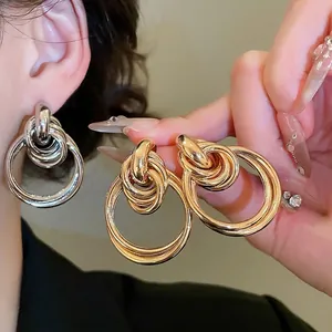 Boucles d'oreilles pendantes circulaires nouées en finitions or et argent