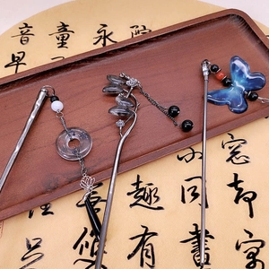 Three elegant vintage metal hair sticks with tassels and butterfly on wooden tray