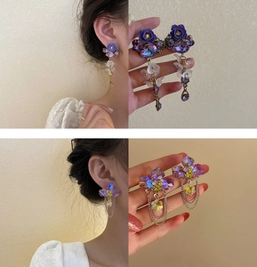 Detail view of floral pearl tassel earrings and purple crystal fringe earrings on model