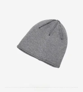 Detail view of the gray knit beanie inner lining and top cross-stitching texture