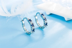 Detail of S925 sterling silver earrings with aquamarine blue gems and white zircons