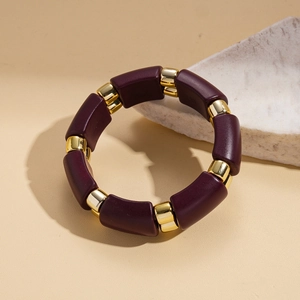 Detail of purple resin blocks and gold alloy links on a minimalist ethnic style bracelet