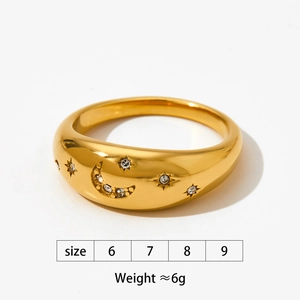 Macro shot of gold stainless steel ring with moon and star carvings and tiny diamonds