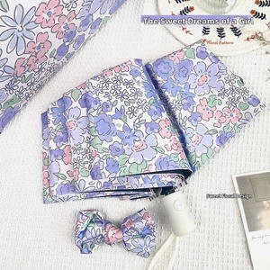 Detail of floral folding umbrella with matching storage bag and bow knot accessory set