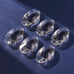 Macro shot of six faceted clear oval crystal pendants on a dark blue background