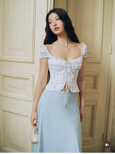 Detail of French vintage floral lace-up corset top paired with a light blue satin skirt