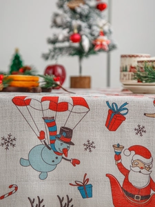 Macro view of Christmas tablecloth with festive snowman and Santa Claus pattern fabric