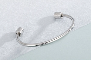 Macro shot of silver polished cuff bracelet ends featuring detailed floral engravings