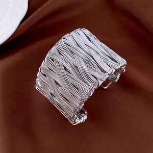 Silver wide braided twist cuff bracelet featuring a minimalist hand-woven metal wire design