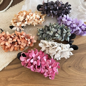 Detail view of colorful 3D fabric flower hair clips with layered acrylic petals design