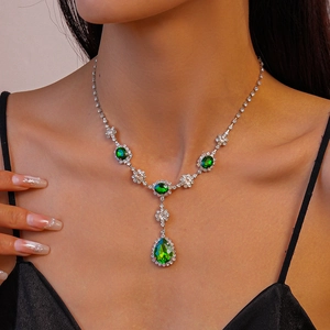 Détail d'un collier en Y argenté avec émeraudes vertes et diamants étincelants de luxe