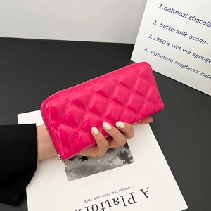 Glossy pink patent leather clutch bag with quilted diamond pattern and gold zipper