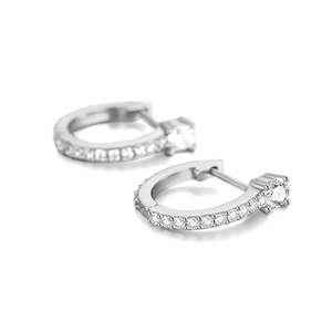 Macro view of silver U-shaped hoop earrings with sparkling cubic zirconia settings