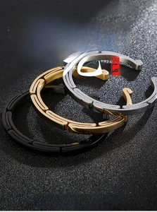 Macro view of minimalist punk style open bangles in black, gold, and silver steel finish