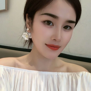 Elegant white camellia flower drop earrings with zircon crystals shown on model