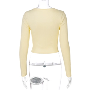 Dettaglio del top corto a maniche lunghe in maglia a coste giallo chiaro sul retro