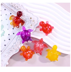 Close-up of six colorful resin turtle charms in red, purple, orange, and yellow hues