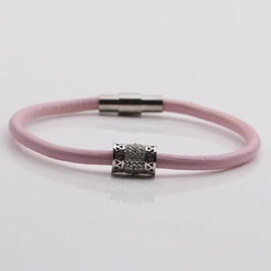 Dettaglio di bracciale intrecciato rosa con cilindro in zirconi e chiusura magnetica