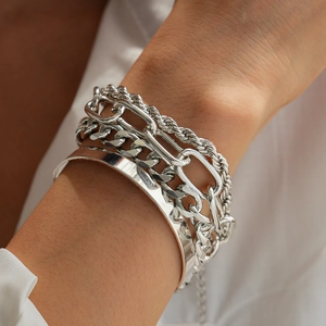 Close-up of a silver 4-piece bracelet set including twist chains and a wide metal cuff